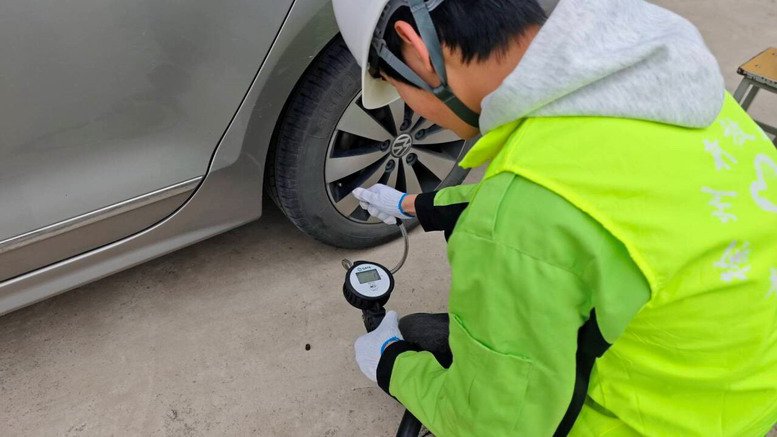 汽車工程學(xué)院團支部學(xué)生為教職工車輛做胎壓檢測